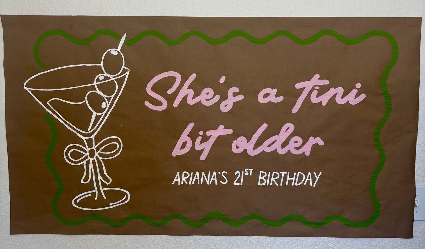 Hand-painted banner: She's a tini bit older, 21st birthday