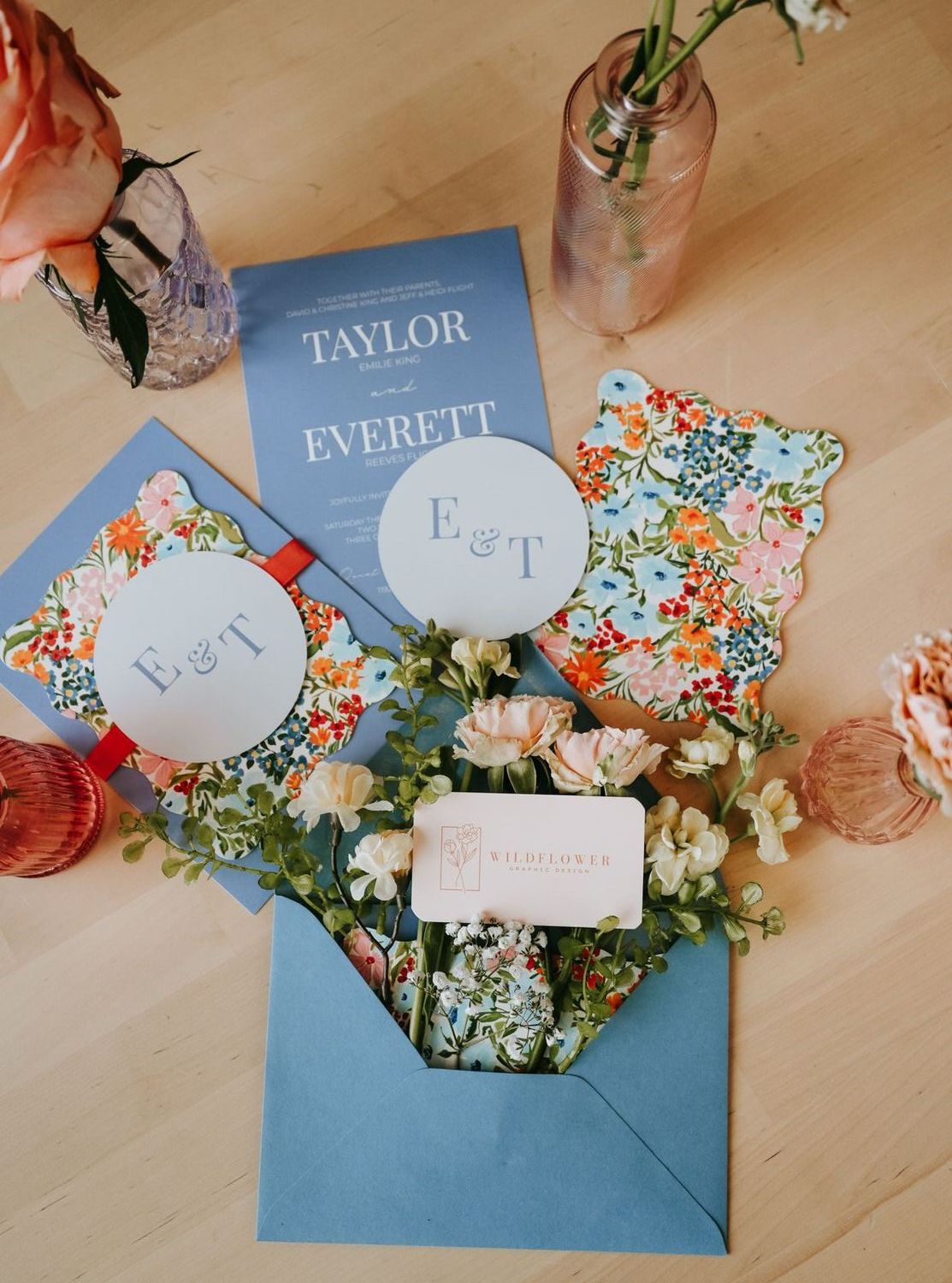 Custom wedding invitation suite with blue envelope, monogram tags and floral liner