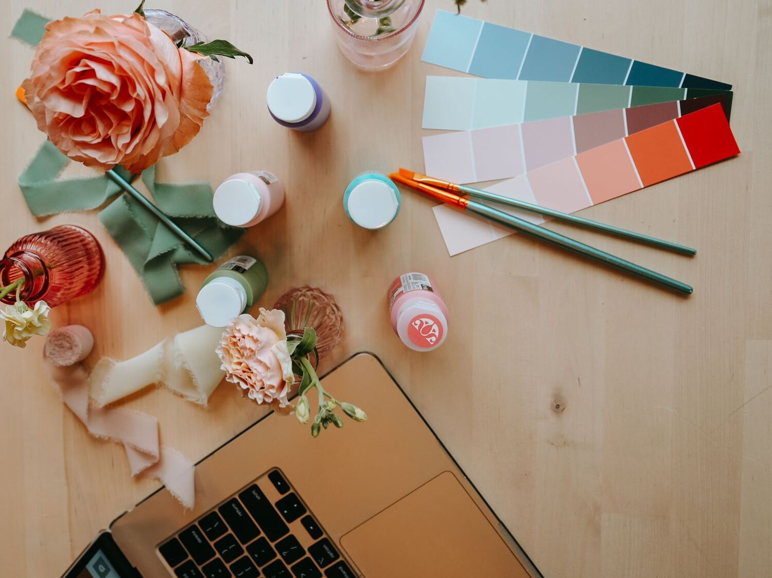 Paint bottles, color swatches and peach roses